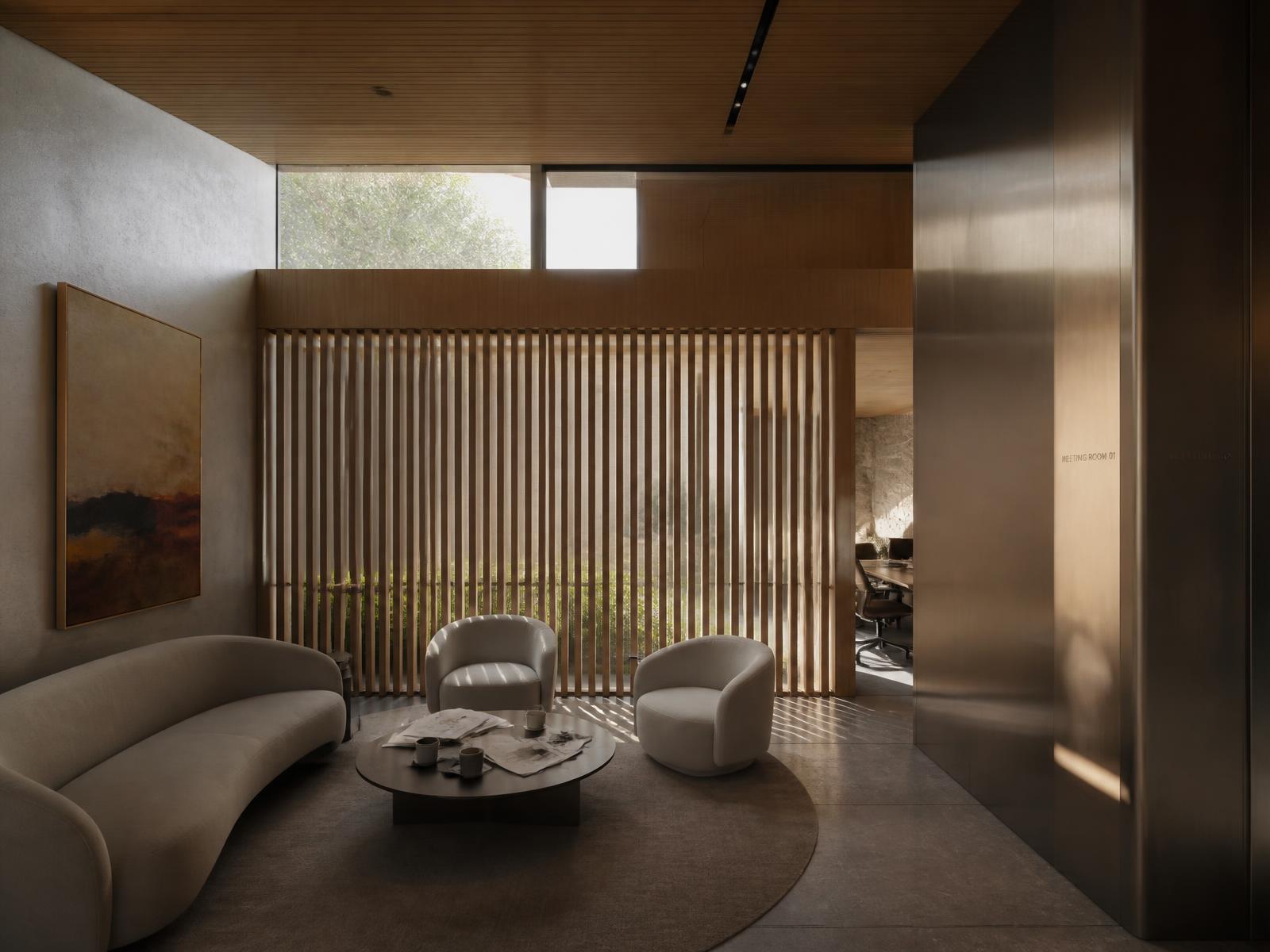 A minimal commercial lounge with warm taupe walls and custom joinery
