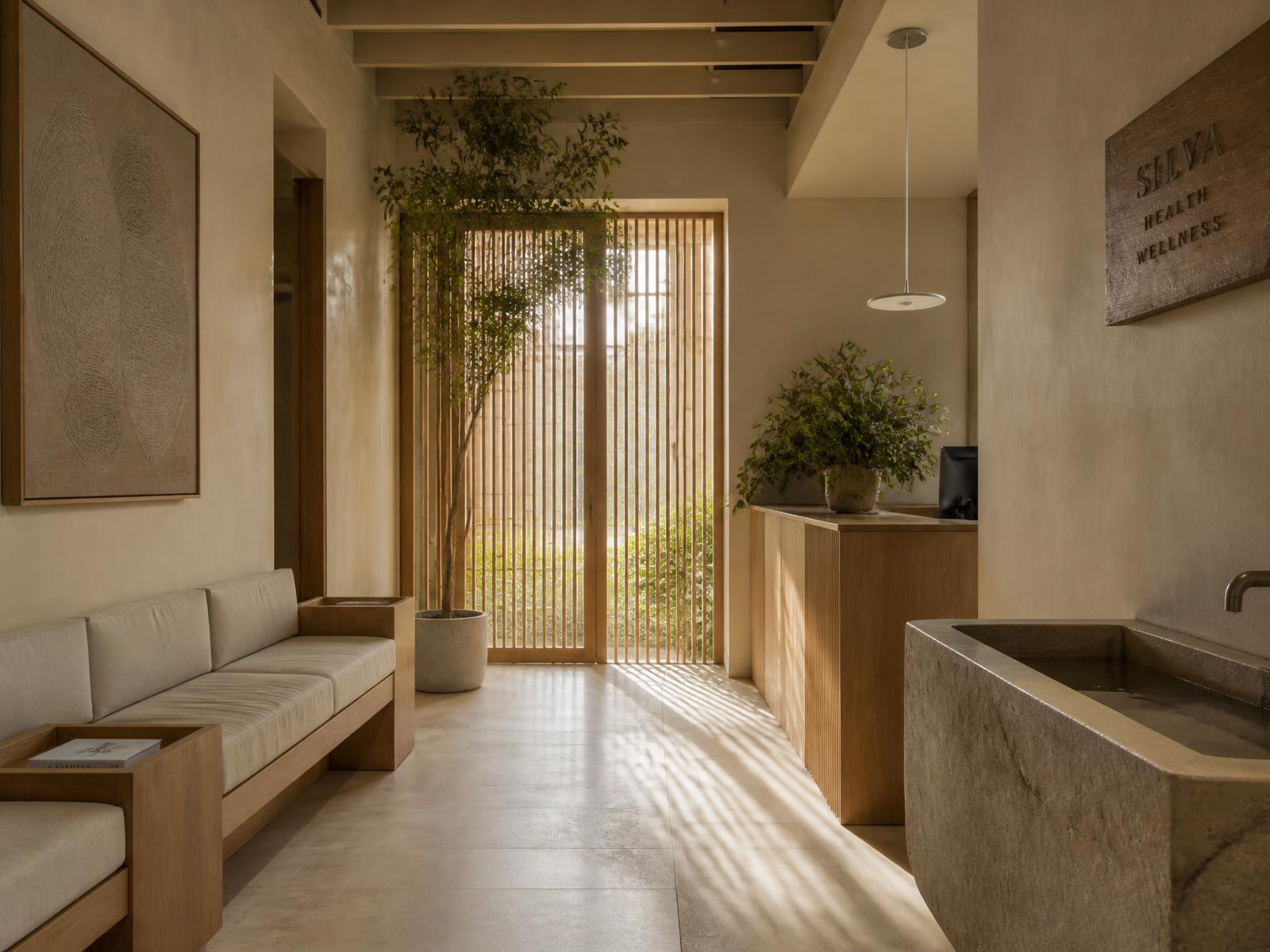 A calm, refined wellness reception with warm oak, natural stone and soft daylight